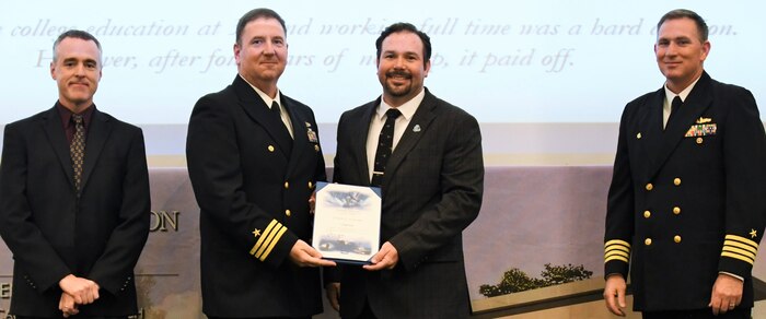 IMAGE: Craig Earls receives his certificate of achievement from Naval Surface Warfare Center Dahlgren Division (NSWCDD) Dam Neck Activity Commanding Officer Cmdr. Joseph Oravec at the 2019 NSWCDD academic recognition ceremony held at the University of Mary Washington Dahlgren campus. Earls was congratulated at the event for completing a bachelor’s degree in electrical engineering from Old Dominion University by Oravec, NSWCDD Commanding Officer Capt. Casey Plew, right, and NSWCDD Deputy Technical Director Darren Barnes.