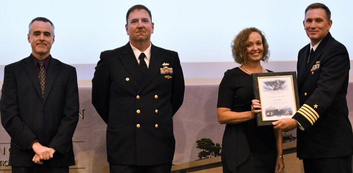 IMAGE: Kendra Miller receives her certificate of achievement from Naval Surface Warfare Center Dahlgren Division (NSWCDD) Commanding Officer Capt. Casey Plew at the 2019 NSWCDD academic recognition ceremony held at the University of Mary Washington Dahlgren campus. Miller was congratulated at the event for completing a master’s degree in technical management from Johns Hopkins University by Plew, NSWCDD Dam Neck Activity Commanding Officer Cmdr. Joseph Oravec and NSWCDD Deputy Technical Director Darren Barnes.