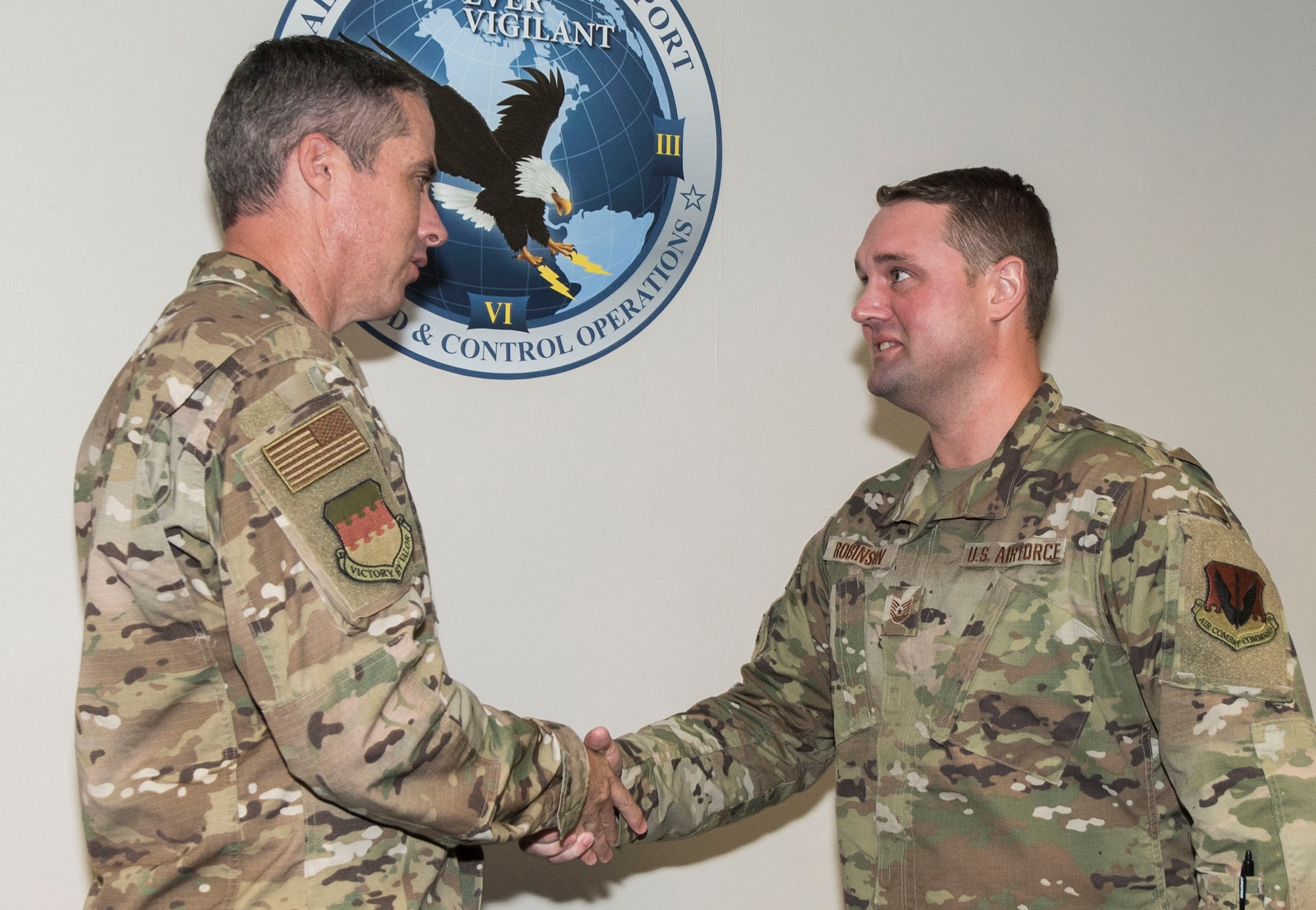 U.S. Air Force Col. Derek O’Malley, 20th Fighter Wing commander, left, coins Tech. Sgt. Adam Robinson, 20th Command Post noncommissioned officer in charge of command and control systems, at Shaw Air Force Base, South Carolina, Oct. 3, 2019.