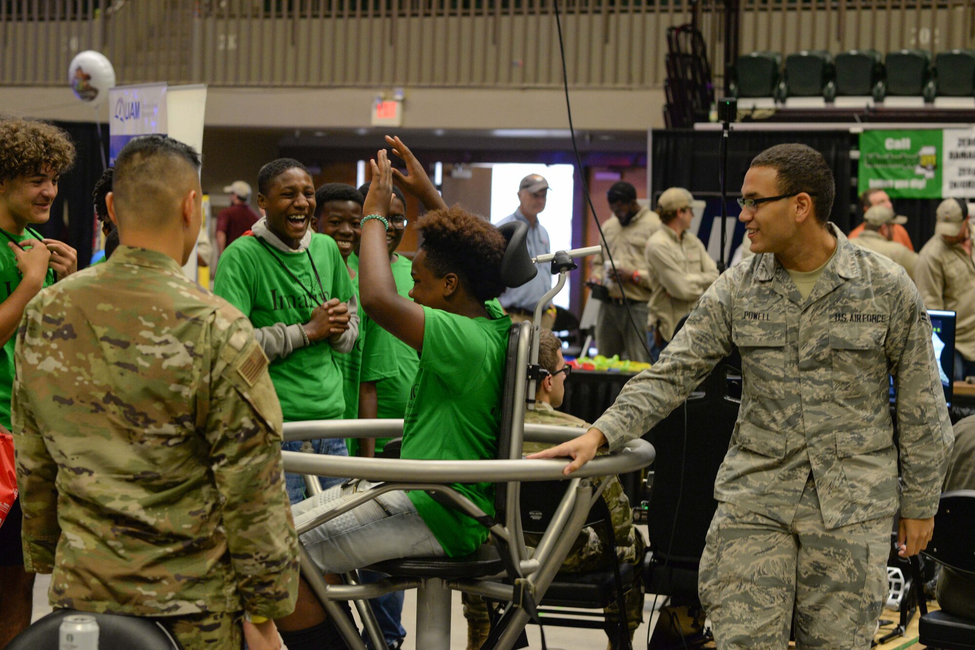 Senior Airman Queneth Salazar, 14th Operational Medical Readiness Squadron aerospace technician, and Airman 1st Class Troy Powell, 14th OMRS aerospace technicians from Columbus Air Force Base, Miss., spin a student in a Barany chair during the Imagine the Possibilities Career Expo Oct. 1, 2019, at the BancorpSouth Arena in Tupelo. A Barany chair is used to simulate spacial disorientation, and show aircrew the effects they may experience while flying. (U.S. Air Force photo by Airman Davis Donaldson)