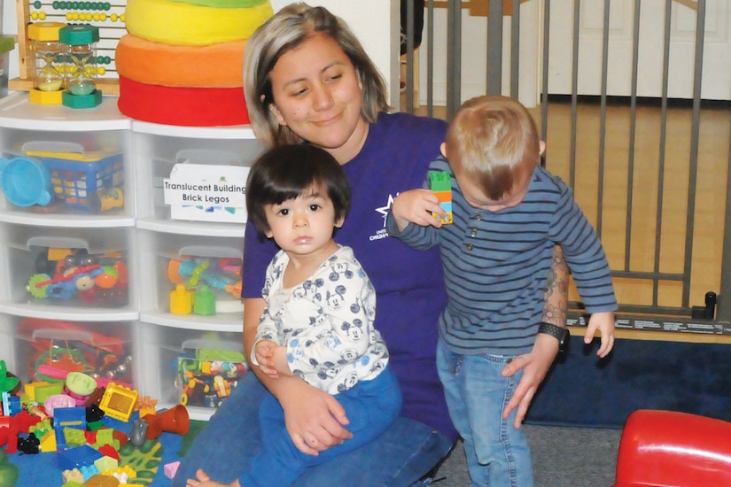 A woman provides care to two children in her home.