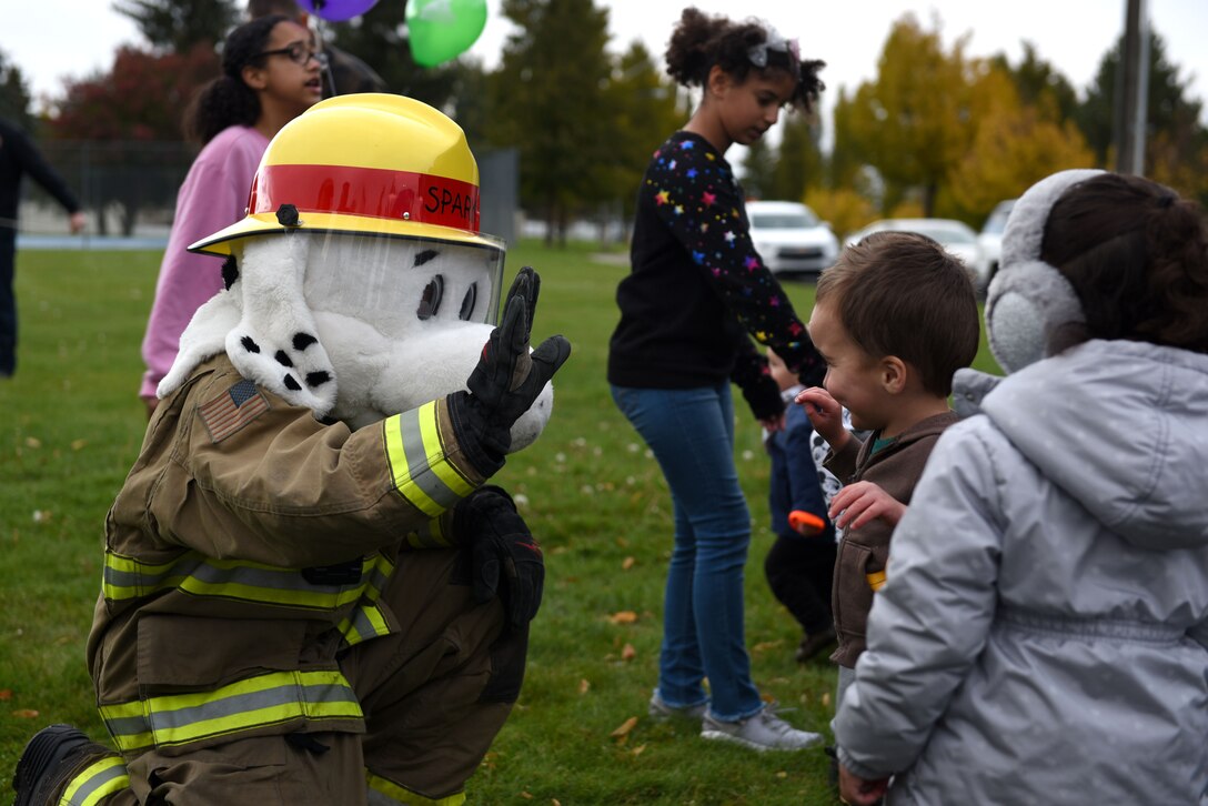 Sparky the Fire Dog, 92nd Civil Engineer Fire Department mascot, greets children at the Fire Prevention Week carnival at Fairchild Air Force Base, Washington, Oct. 7, 2019