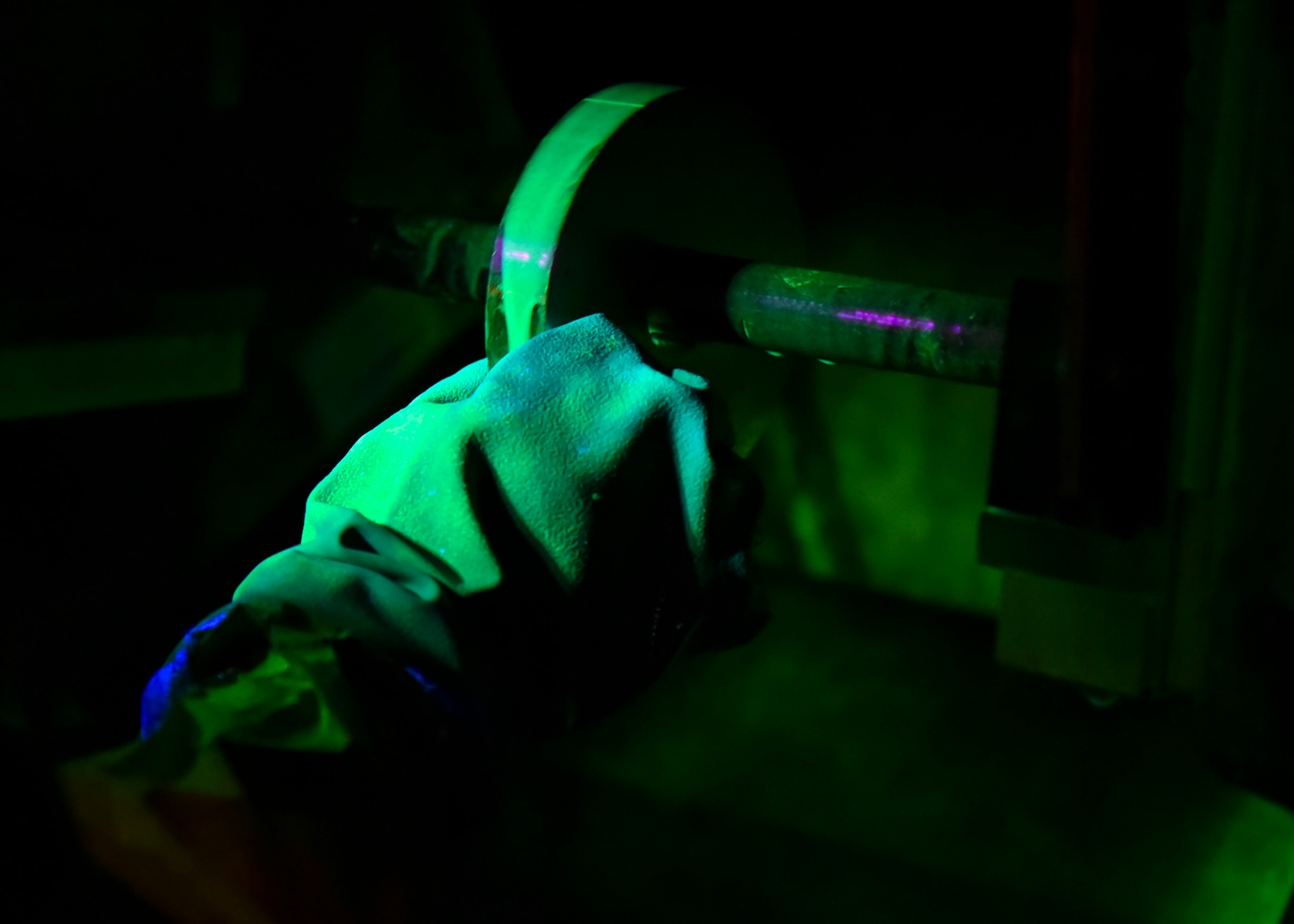U.S. Air Force Airman 1st Class Patrick Torres, 92nd Maintenance Group non-destructive inspection technician, tests a piece of metal with a magnetic machine to see if it detects holes through the metal at Fairchild Air Force Base, Washington, Sept 9, 2019. 
The material tested will show a neon line across the top if magnets indicate there is a hole in the piece of material being tested. (U.S. Air Force photo by Airman Kiaundra Miller)