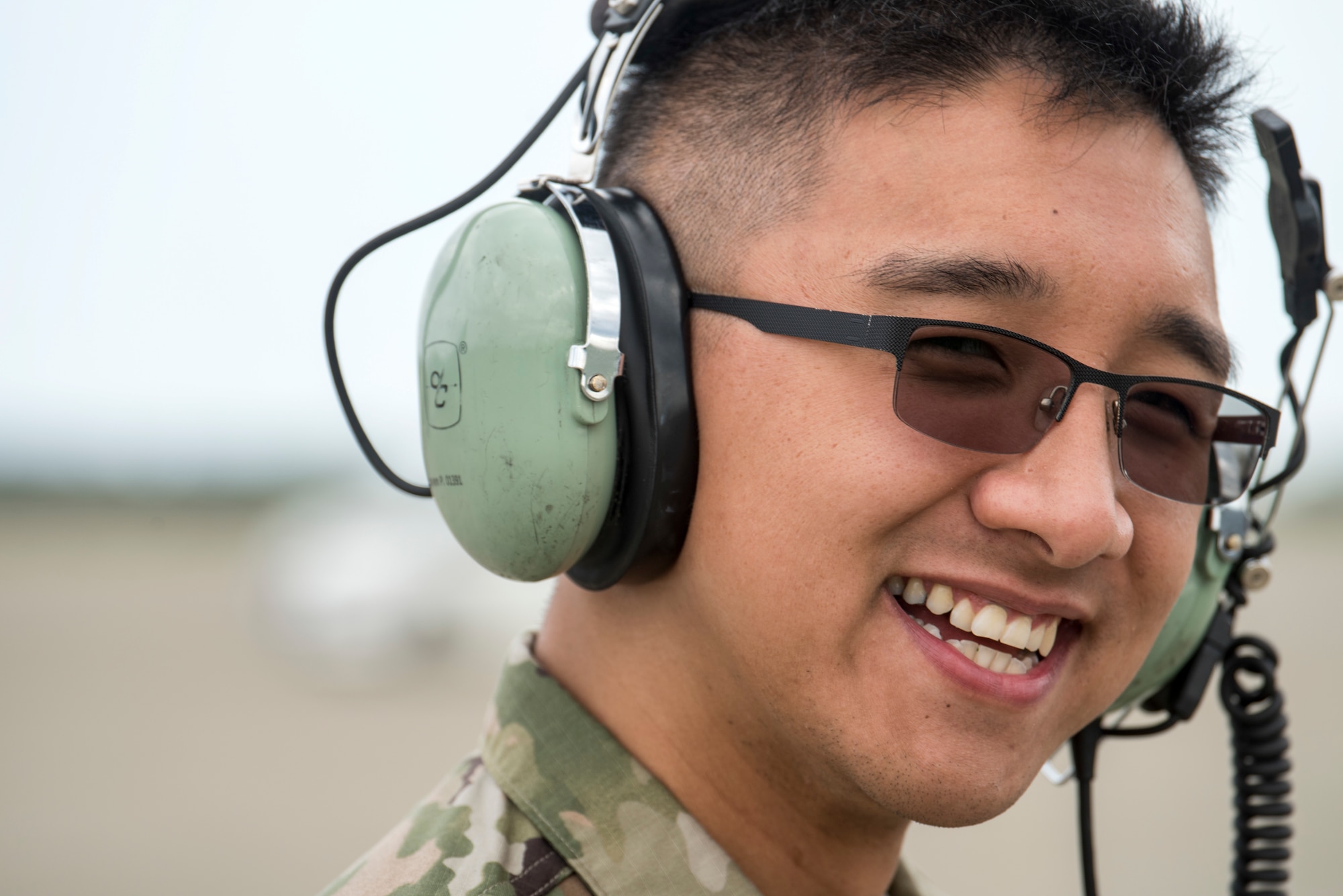 U.S. Air Force Senior Airman Peter Nguyen, a 13th Aircraft Maintenance Unit F-16 Fighting Falcon assistant dedicated crew chief, smiles while marshalling an F-16 during an aviation training relocation at Komatsu Air Base, Japan, Oct. 3, 2019. Capt. Phillip McCoy, a 13th Fighter Squadron F-16 pilot and Komatsu ATR detachment commander, described the ATR participants as hard working, consistent and dedicated to the mission of executing bilateral training sorties regardless of unexpected changes, such as inclement weather experienced during the week-long exercise. The 13th AMU and its Airmen are assigned to Misawa AB. (U.S. Air Force photo by Senior Airman Collette Brooks)