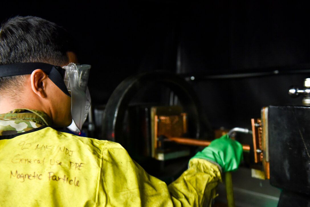U.S. Air Force Airman 1st Class Patrick Torres, 92nd Maintenance Group non-destructive inspection technician, prepares a rod to magnetically test a product on Fairchild Air Force Base, Washington, Sept. 5, 2019. Magnets are one of six methods used to detect cracks and weakened spots on aircraft parts, potential issues that other maintenance career fields would not be able to identify without taking the KC-135 apart. (U.S. Air Force photo by Airman Kiaundra Miller)