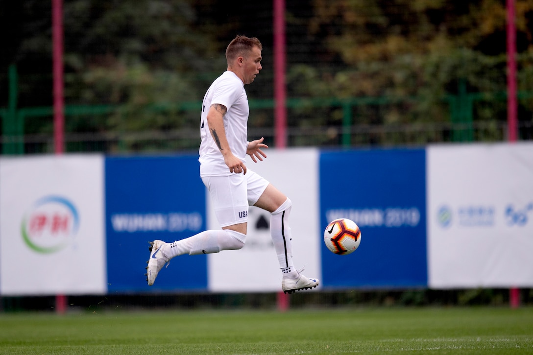 An Air Force athlete kicks a soccer ball midair