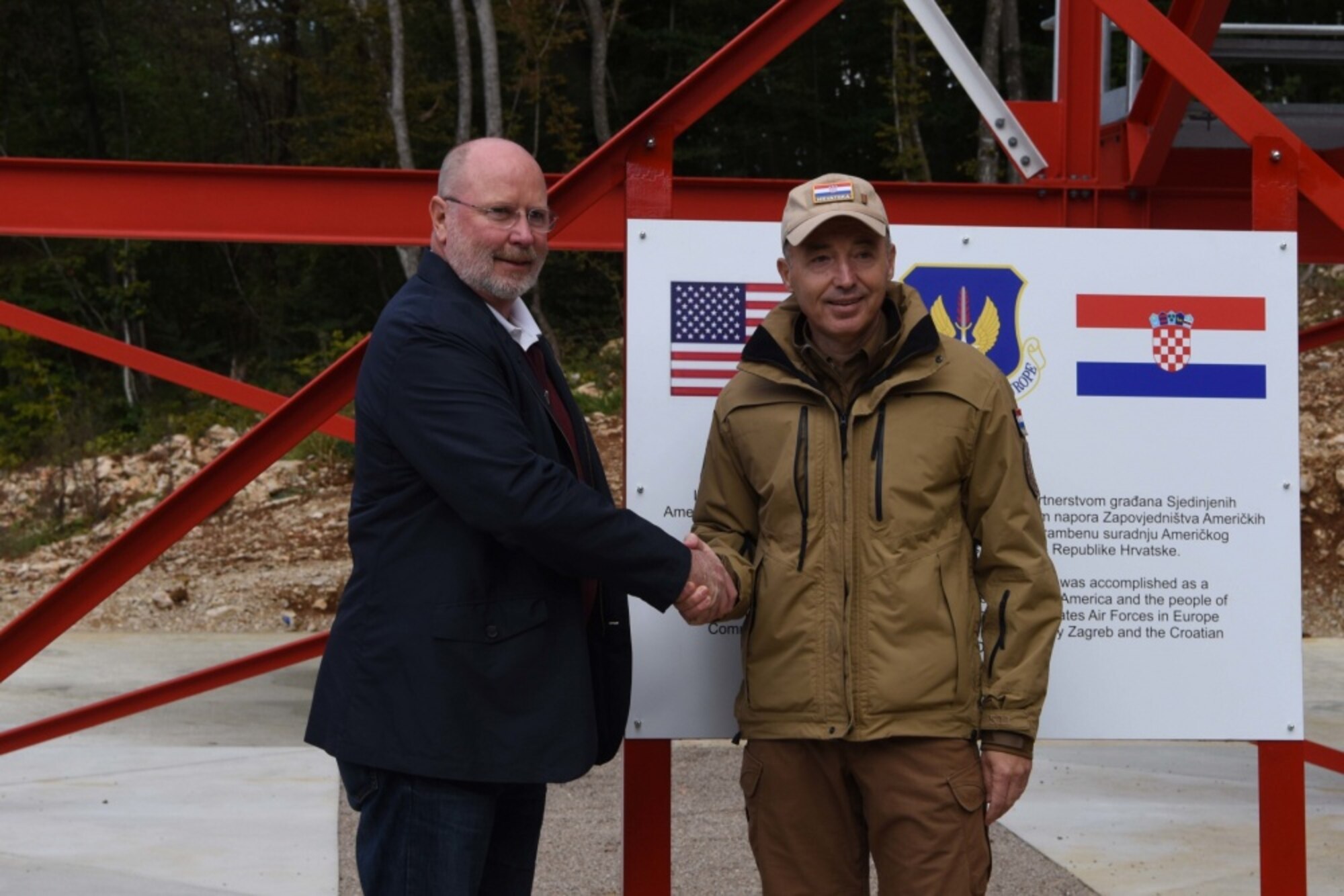 Robert Kohorst, U.S. ambassador to Croatia (left) and Damir Krsticevic, Croatian minister of defense, shake hands during the grand opening of a range observation tower ceremony at Slunj Training Area, Croatia, Oct. 4, 2019. Kohorst attended to show support for the joint construction project, showing the strength of the partnership between the two countries. (U.S. photo by Senior Airman Milton Hamilton)