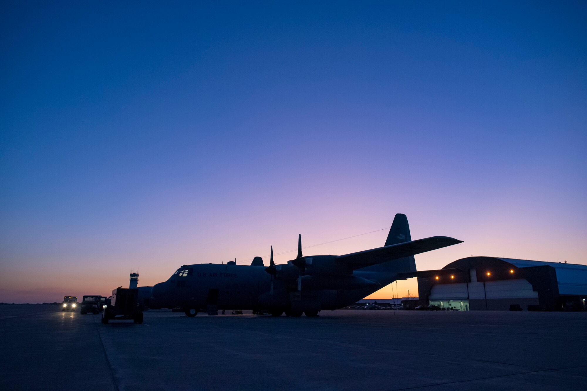 Photo of the sun rising over the flight line of C-130H Hercules.