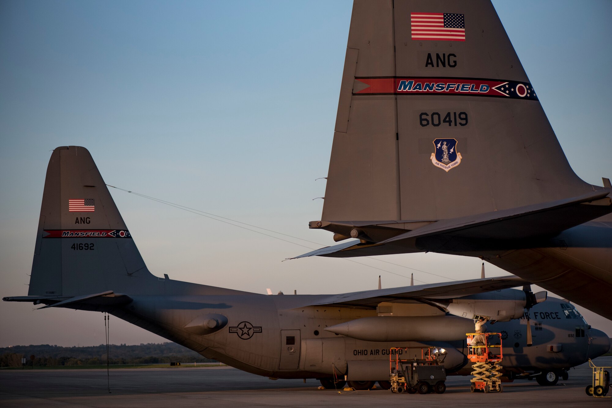 photo of 2 C-130's sitting on the flight line, early morning.