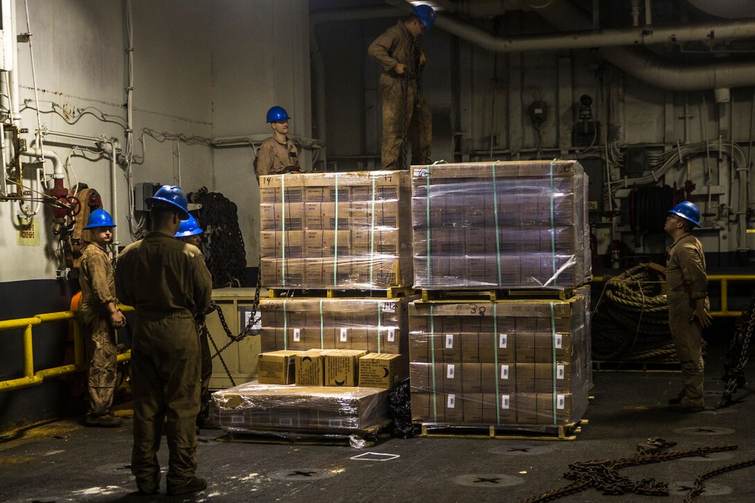 U.S. Marines with the 26th Marine Expeditionary Unit move and secure cargo aboard the amphibious assault ship USS Bataan (LHD 5) during composite training unit exercise in the Atlantic Ocean Oct. 9, 2019. Combat cargo Marines are key members of the team that ensure all gear and equipment is loaded safely and efficiently. (U.S. Marine Corps photo by Cpl. Tanner Seims)