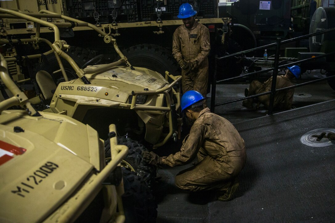 U.S. Marines with the 26th Marine Expeditionary Unit move and secure cargo aboard the amphibious assault ship USS Bataan (LHD 5) during composite training unit exercise in the Atlantic Ocean Oct. 9, 2019. Combat cargo Marines are key members of the team that ensure all gear and equipment is loaded safely and efficiently. (U.S. Marine Corps photo by Cpl. Tanner Seims)