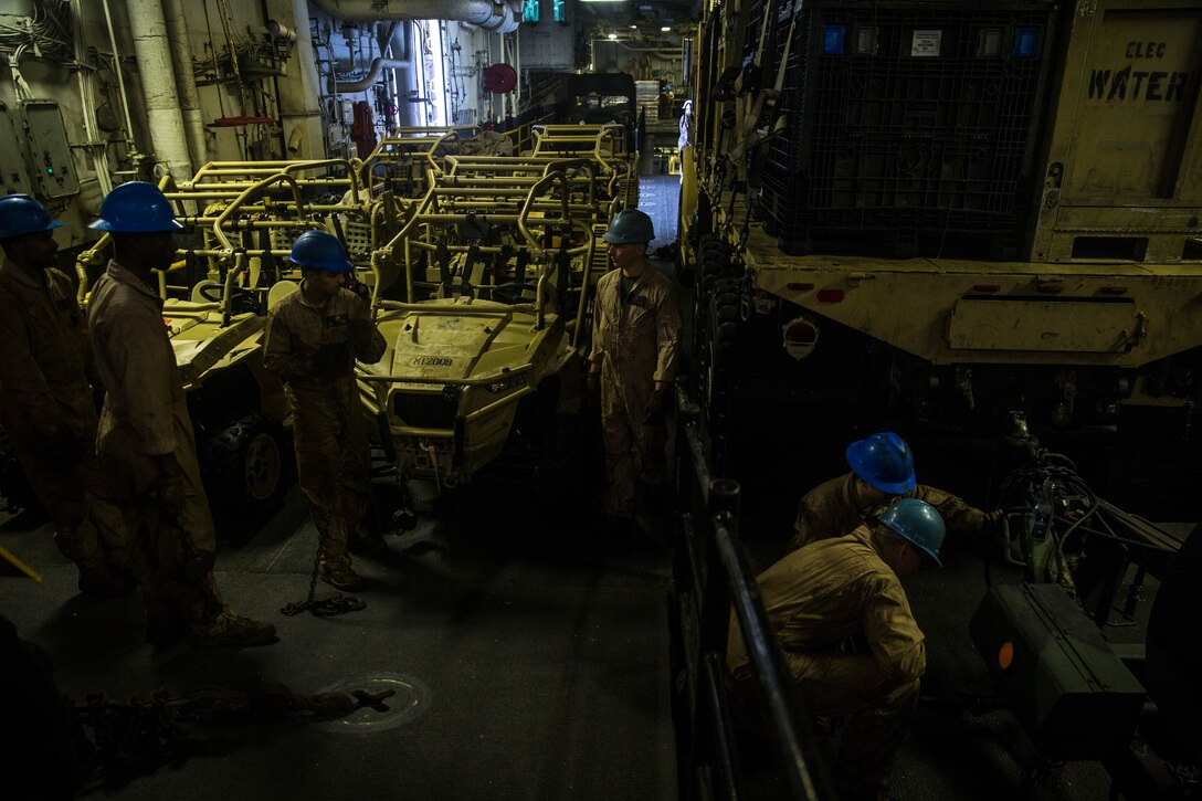 U.S. Marines with the 26th Marine Expeditionary Unit move and secure cargo aboard the amphibious assault ship USS Bataan (LHD 5) during composite training unit exercise in the Atlantic Ocean Oct. 9, 2019. Combat cargo Marines are key members of the team that ensure all gear and equipment is loaded safely and efficiently. (U.S. Marine Corps photo by Cpl. Tanner Seims)