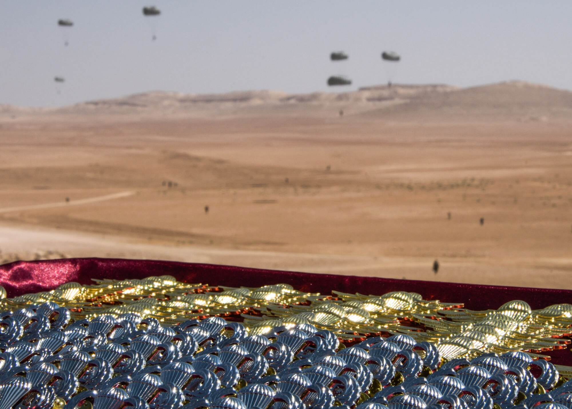 A set of jump wings prepared for the pinning ceremony that takes place after the Friendship Jump remains in focus as the jumper’s parachute to the Jordanian ground during Exercise Eager Lion on Sept. 5, 2019.