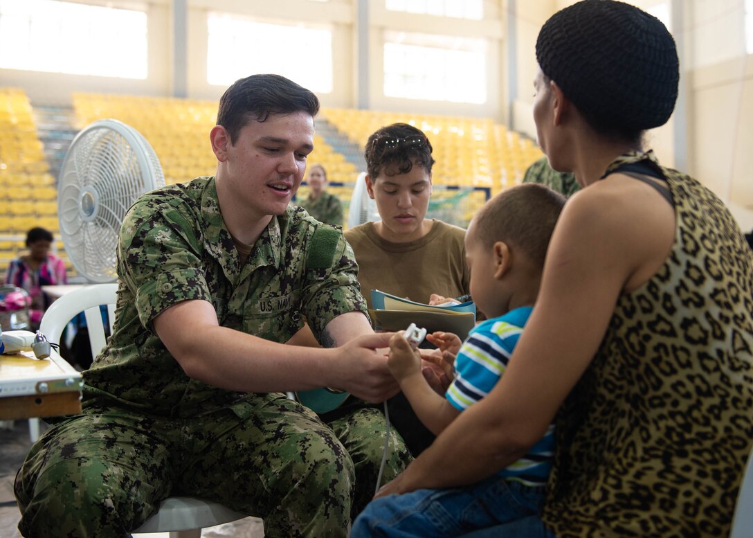 A U.S. Navy Hospital Corpsman checks a boy's vital signs.