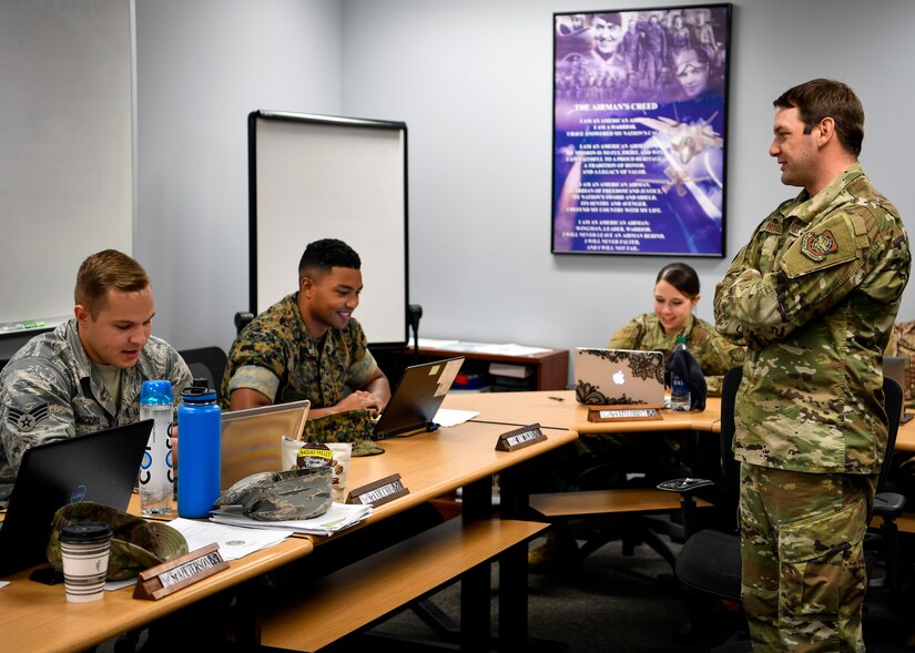 U.S. Air Force Staff Sgt. Tyler Ingalls, Kish Airman Leadership School instructor, converses with students during class Oct. 7, 2019 at Kish ALS on Joint Base McGuire-Dix-Lakehurst, New Jersey. As the only tri-service military installation throughout the Department of Defense, the Kish ALS leadership reached out to all units on Joint Base MDL and throughout the local area to create the first ever class consisting of all five uniformed services to build a more ready force across the DoD.