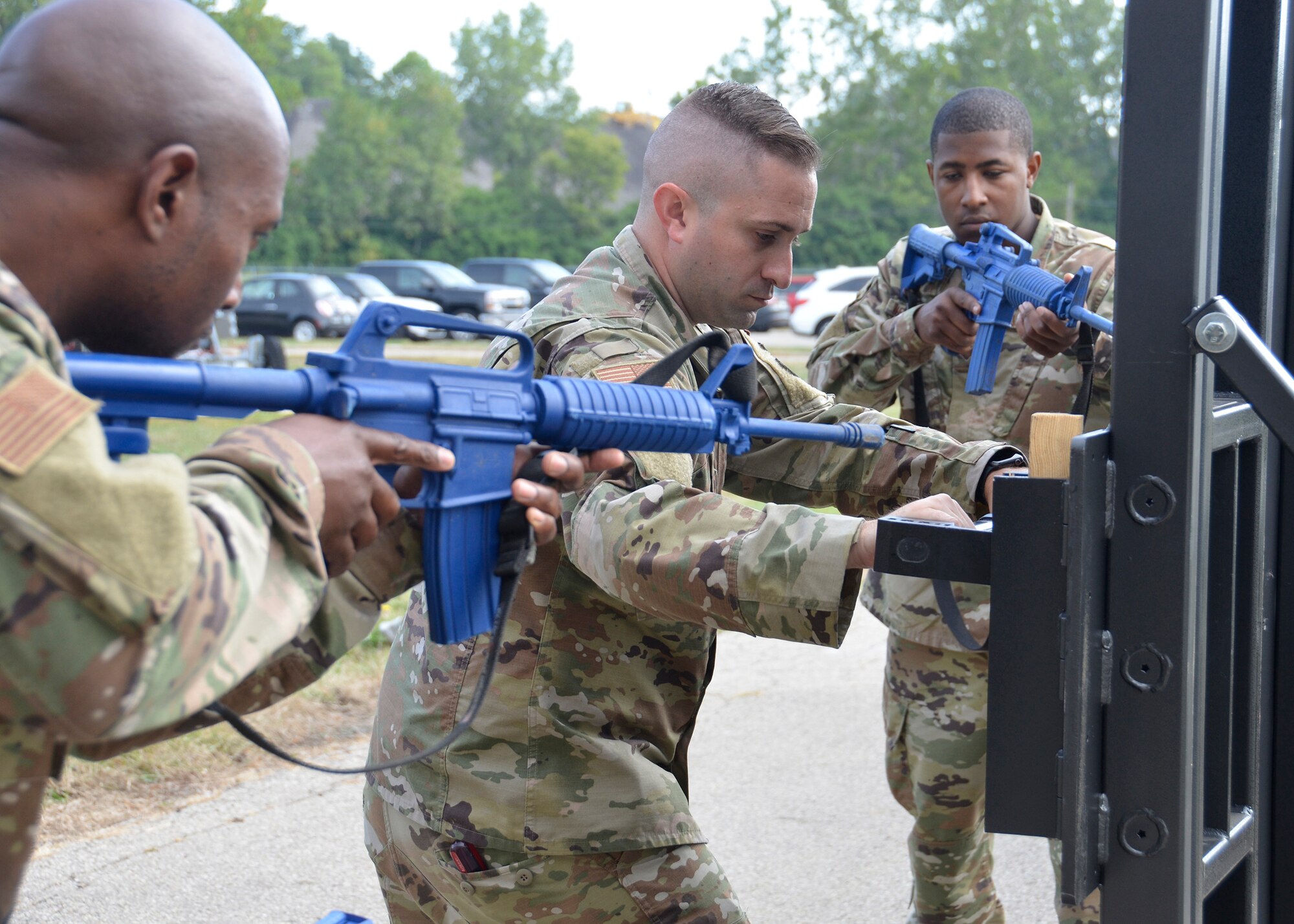 Staff Sgt. Chris Bell, fire team member, Tech. Sgt. Nathan Ellcessor, fire team leader, and Senior Airman Daryn Weatherspoon, fire team member, all with the 445th Security Forces Squadron, demonstrate the proper way to use a tool called a hooligan to force open a locked door September 8, 2019. The demonstration was part of a door-breaching training which included about 30 Airmen and offered hands-on practice with multiple specialized tools. (U.S. Air Force photo/1st Lt. Rachel Ingram)