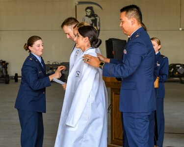 U.S. Air Force Capt. Song Moon, 633rd Medical Group Interservice Physician Assistant Program deputy program director, puts on the new PA’s white coats during a white coat ceremony at Joint Base Langley-Eustis, Virginia, Oct. 3, 2019.