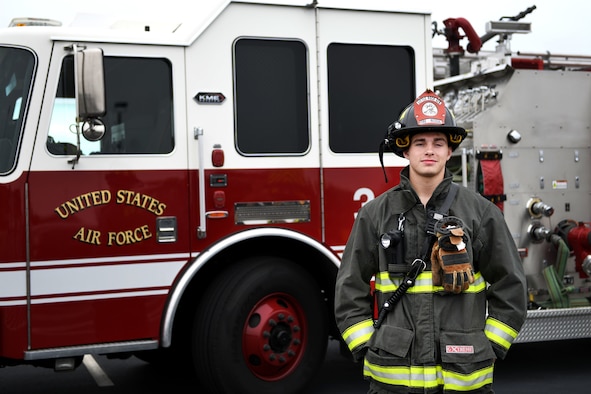 A man stands in front of a fire truck.