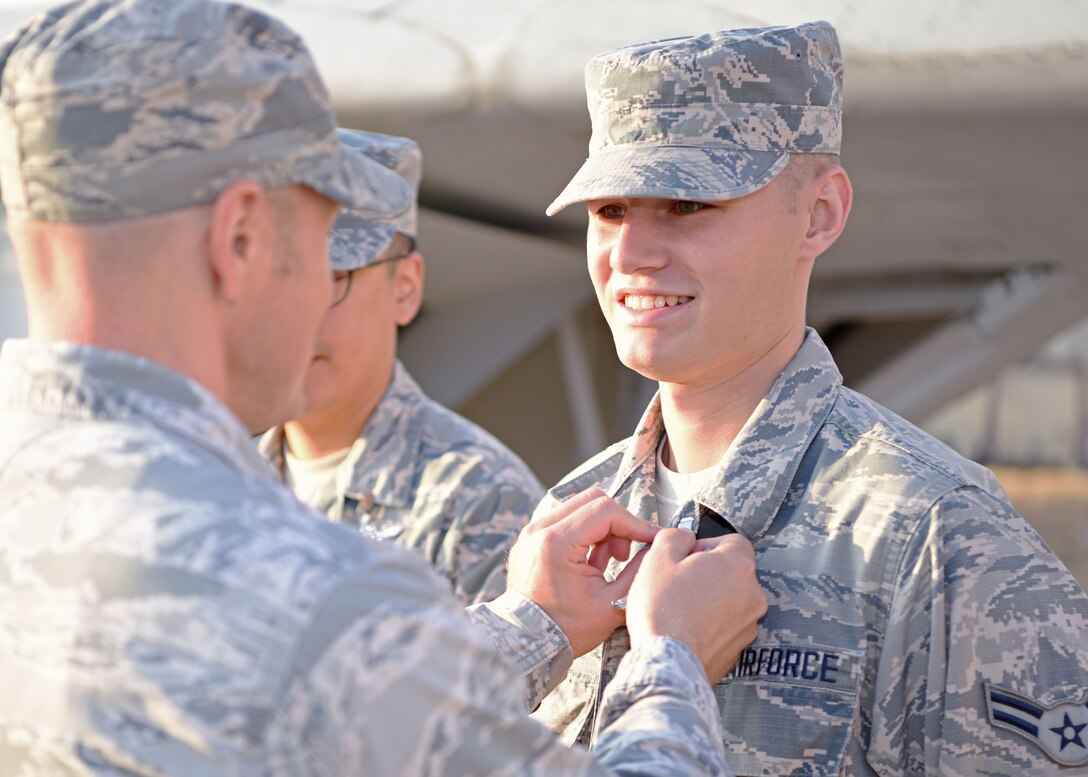 U.S. Air Force Lt. Col. Chris Sharp, 316th Training Squadron commander, pins Airman 1st Class Noah Sharp, a recent linguist graduate, with his job badge at Goodfellow Air Force Base, Texas, Sept. 11, 2019. Noah’s father had the honor of pinning him and officially making him a graduate of the linguist course. (U.S. Air Force photo by Airman 1st Class Ethan Sherwood/Released)