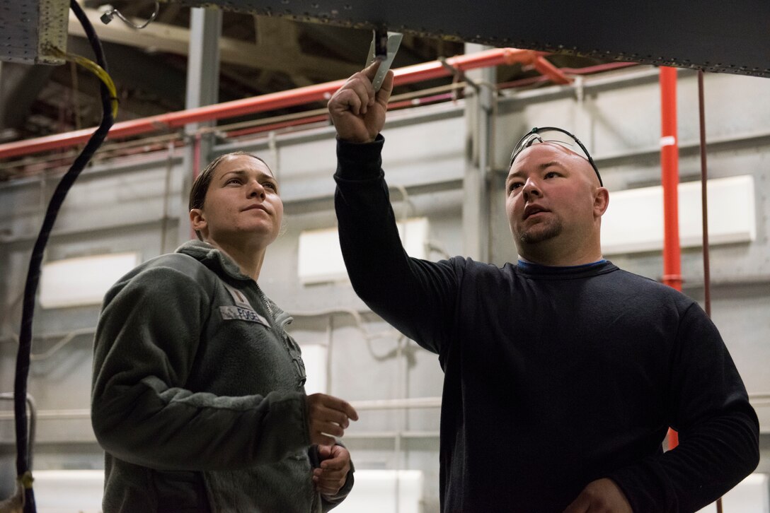 Josh Collins, 402nd Commodities Maintenance Group, aircraft structural mechanic explains to 2nd Lt. Emily Fogel, 366th Maitencance Group, the process of installing a spar repair piece on an F-15E Strike Eagle Oct 4, 2019, at Mountain Home Air Force Base, Idaho. The repair was done in order to preserve the mission readiness of the aircraft. (U.S. Air Force photo by Senior Airman Tyrell Hall)
