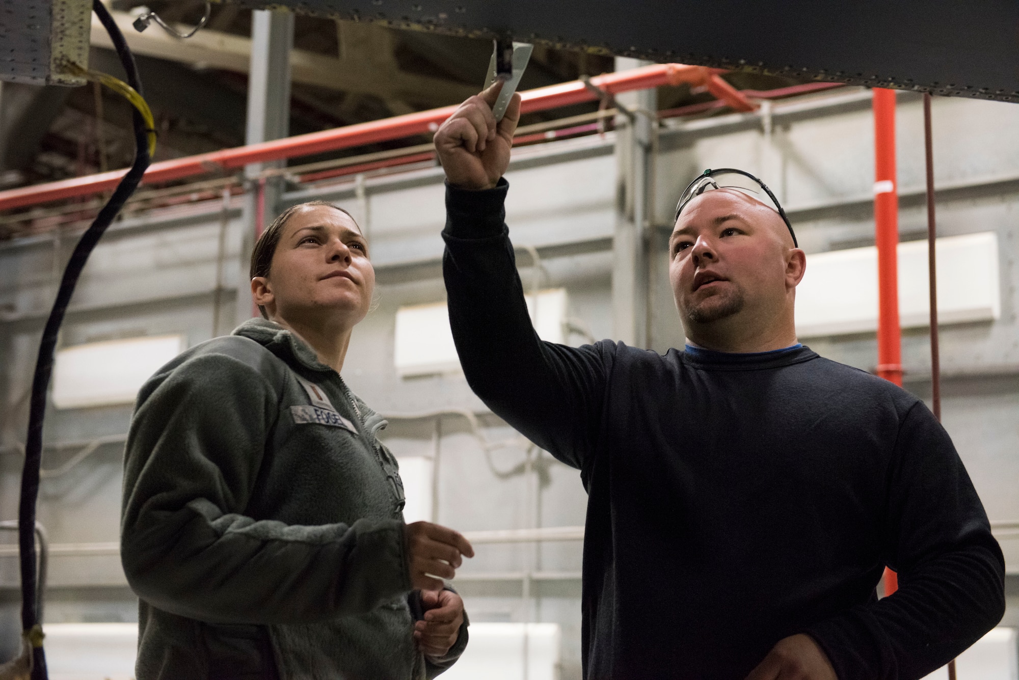 Josh Collins, 402nd Commodities Maintenance Group, aircraft structural mechanic explains to 2nd Lt. Emily Fogel, 366th Maitencance Group, the process of installing a spar repair piece on an F-15E Strike Eagle Oct 4, 2019, at Mountain Home Air Force Base, Idaho. The repair was done in order to preserve the mission readiness of the aircraft. (U.S. Air Force photo by Senior Airman Tyrell Hall)