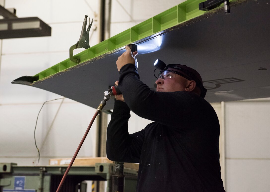 Josh Collins, 402nd Commodities Maintenance Group, aircraft structural mechanic, drills bolt sites into a leading edge wing in perparation to conduct a repair on an F-15E Strike Eagle Oct 4, 2019, at Mountain Home Air Force Base. The repair was done in order to preserve the mission readiness of the air craft. (U.S. Air Force photo by Senior Airman Tyrell Hall)