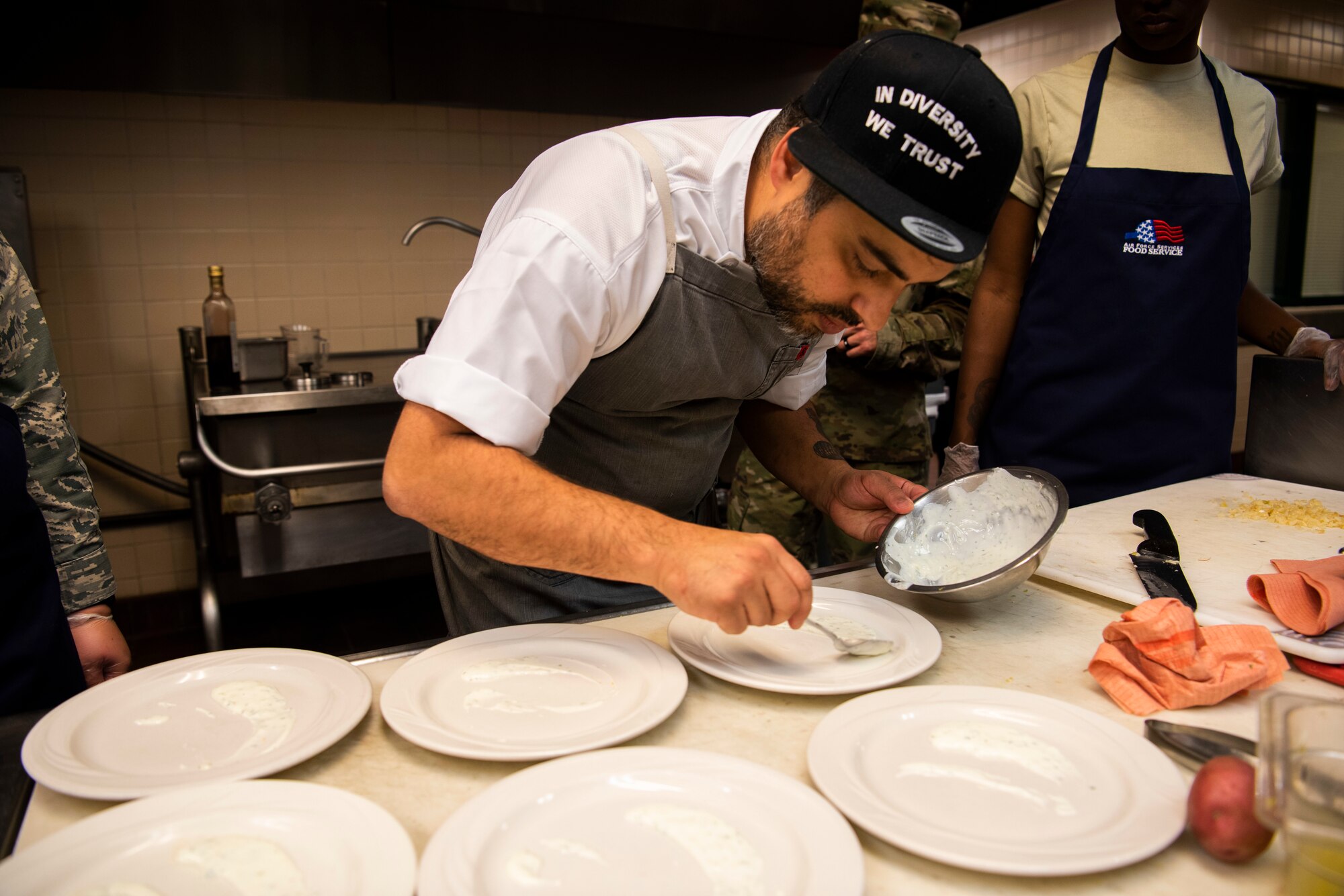 Chef David Viana, USO Celebrity Chef Tour participant, teaches his team about restaurant quality food plating during a cooking competition Oct. 15, 2019, at F.E. Warren Air Force Base, Wyo. The competition allowed the Airmen participant to develop additional culinary skills and provided good practice for deployments. (U.S. Air Force photo by Senior Airman Abbigayle Williams)