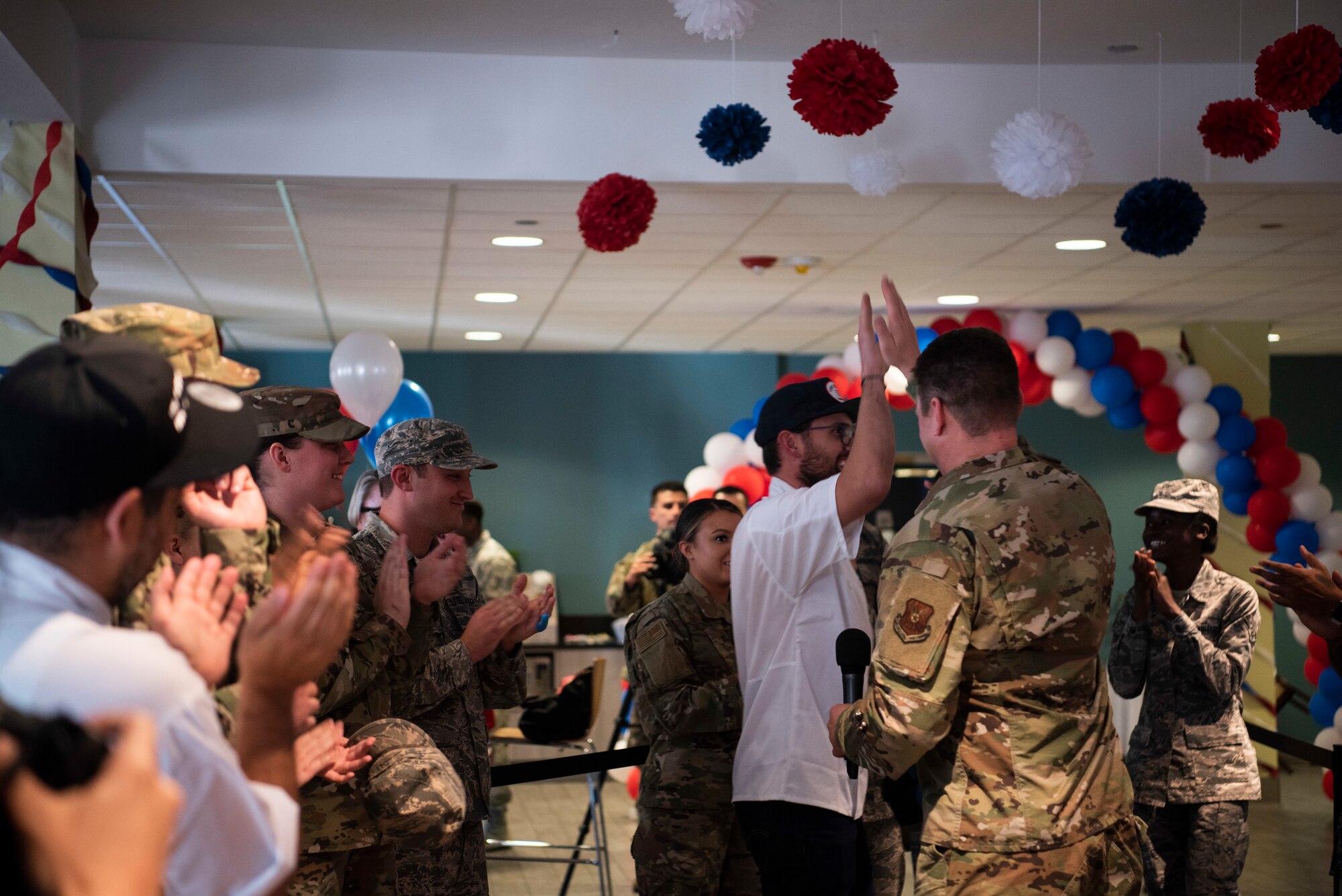 Chef Kevin Scharpf, USO Celebrity Chef Tour participant, high fives Col. Peter Bonetti, 90th Missile Wing commander, after the announcement he team, Chop It Like It’s Hot, won the cooking competition Oct. 15, 2019, at F.E. Warren Air Force Base, Wyo. The winning Airmen were coined by Bonetti and given a two-day pass from work. (U.S Air Force photo by Senior Airman Abbigayle Williams)