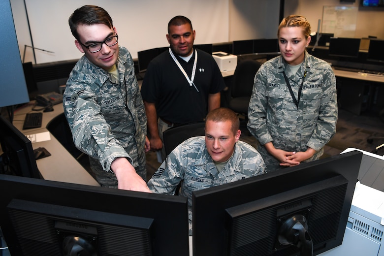 Senior Master Sgt. Blair Burdick II, center, 2nd Space Operations Squadron superintendent, gives the last command to decommission Satellite Vehicle Number-38, while Airman 1st Class David Valentine, left, 2nd SOPS satellite system operator; Arturo Martínez, center back, Boeing engineer; and 1st Lt. Kristina Brandes, right, 2nd SOPS chief bus system analyst, observe on Schriever Air Force Base, Colorado, Oct. 9, 2019. The squadron surprised Burdick, who will retire from the Air Force in March 2020, with the opportunity to decommission the 22-year-old satellite from service. This SVN-38 is being decommissioned to make way for GPS-III satellites, the first one was launched on December 2018. (U.S. Air Force photo by Katie Calvert)