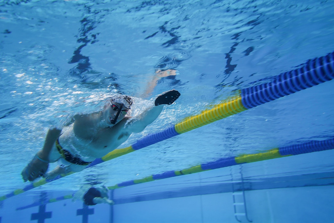 A Marine swims laps in a pool.