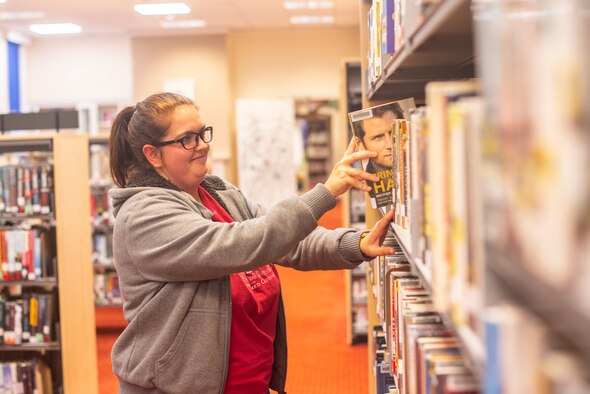 Sarah Lloyd, 100th Force Support Squadron library technician, shelves a book at the base library Oct. 16, 2019, at RAF Mildenhall, England. The library offers an assortment of resources for Airmen and families to take advantage of including the latest fiction and nonfiction books and audiobooks, test preparation and language learning materials, and public computer access.  (U.S. Air Force photo by Airman 1st Class Joseph Barron)