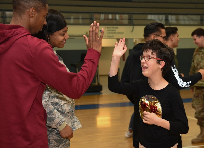 U.S. Airmen and the child of a DoD service member congratulate each other after a “Vogelweh Gym Session” at Vogelweh Military Complex, Germany, Oct. 9, 2019. Active duty service members are invited to sign up and play with special needs children on the second Wednesday of each month during the school year.