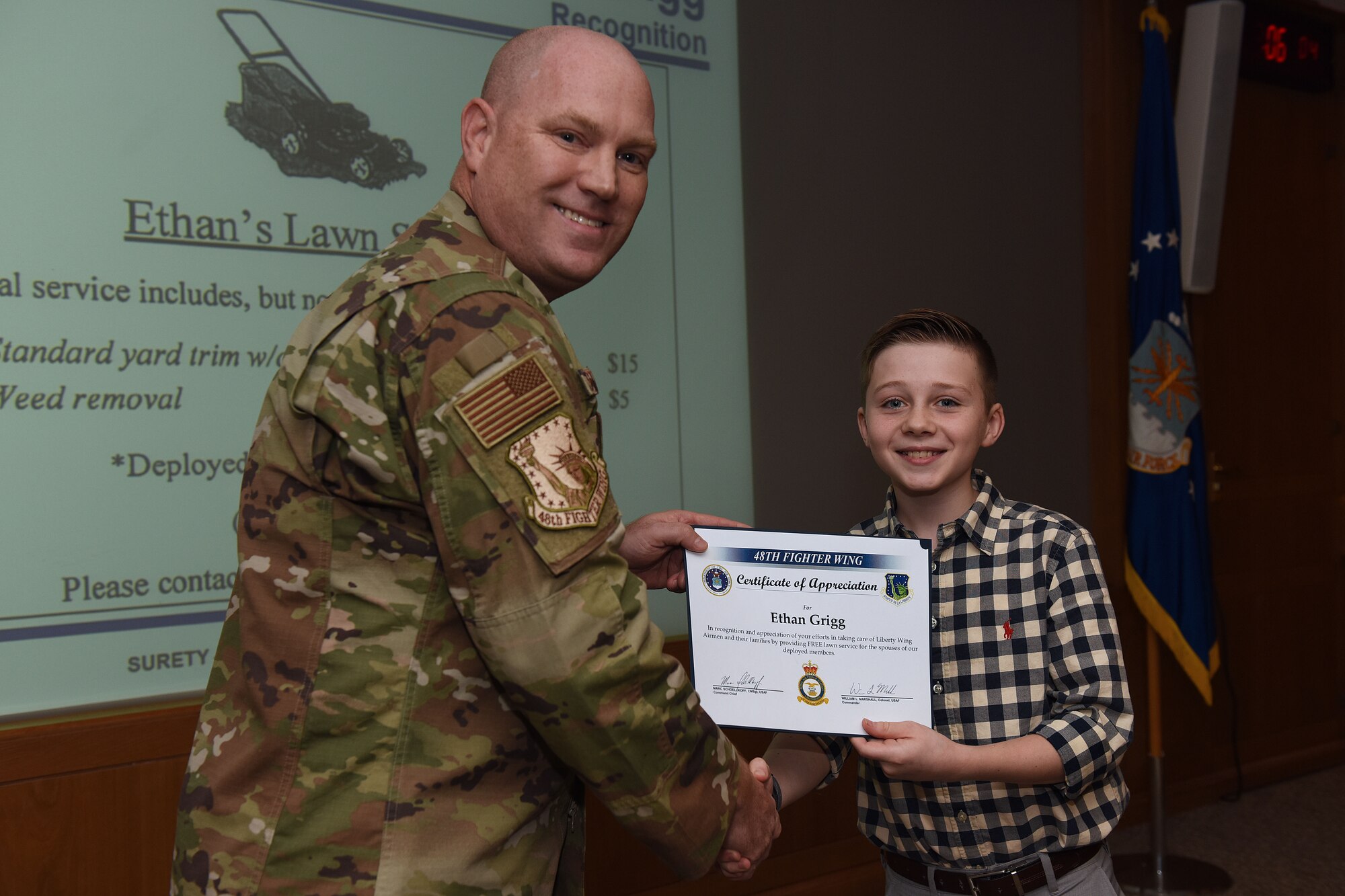 Col. John Stratton, 48th Fighter Wing vice commander, presents a certificate of appreciation to Ethan Grigg, son of U.S. Air Force Master Sgt. Daniel Grigg, 748th Aircraft Maintenance Squadron weapons section chief, at Royal Air Force Lakenheath, England, Oct. 15, 2019. Ethan was recognized for offering free yard trimming for deployed families across the Liberty Wing. (U.S. Air Force photo by Senior Airman Shanice Williams-Jones)