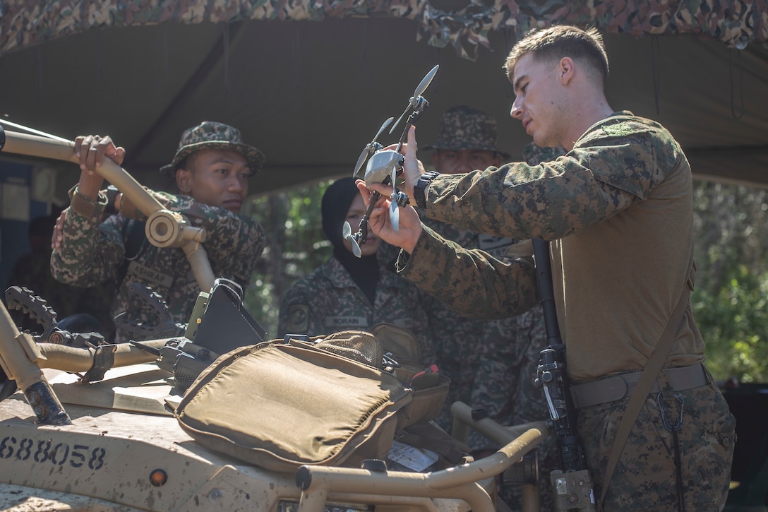 191003-M-ET529-1003 MALAYSIA (Oct. 3, 2019) U.S. Marine Corps Sgt. Matthew Scott, the company intelligence specialist with Lima Company, Battalion Landing Team, 3/5, 11th Marine Expeditionary Unit, shows members of the Malaysian Armed Forces a remote controlled drone during Tiger Strike 2019. U.S. Marines and Sailors joined Malaysian Armed Forces for exercise Tiger Strike 2019 where both forces participated in jungle survival, amphibious assault, aerial raids, and combat service support training and cultural exchanges (U.S. Marine Corps photo by Cpl. Israel Chincio)
