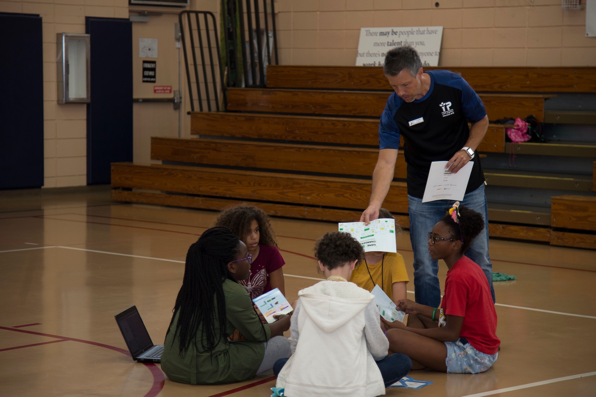 Chris Hug, 6th Force Support Squadron youth programs director, hands instruction cards to MacDill Youth Center members, Oct. 9, 2019, at MacDill Air Force Base, Fla. The MacDill Youth Center and 4-H team members with Hillsborough County hosted a 4-H National Youth Science Day to introduce MacDill’s youth to computer science and programming. (U.S. Air Force photo by Airman 1st Class Shannon Bowman)