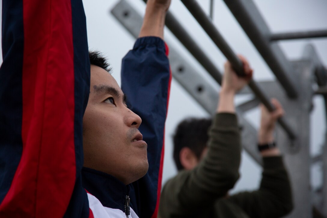 A member of the Japan Ground Self-Defense Force performs pull-ups during physical training on Combined Arms Training Center Camp Fuji, Gotemba, Japan, Oct. 17, 2019. The JGSDF toured the base to learn operations of U.S. Marines, practice speaking English, and to strengthen the relationship between two nations.