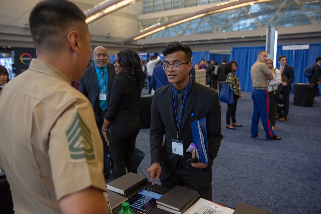 Gunnery Sgt. Nicholas Haro, a Cyberspace Exploitation Operator with Marine Forces Cyber Command, discusses career possibilities with Tanoy Sarkar, a senior at City College of New York, during the Society of Asian Scientists and Engineers (SASE) National Conference career fair in Pittsburgh, Pennsylvania, October 12, 2019. SASE consists of more than 100 college chapters and was founded to give engineering students of Pan-Asian decent an opportunity to achieve their full potential while connecting and supporting one another. The presence of Marines at the SASE National Conference creates a reminder that Marines are supportive of the organization, its efforts and the communities it represents. (U.S. Marine Corps photo by Lance Cpl. Mitchell Collyer)