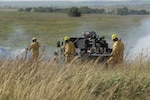 A group of Soldiers and Airmen from the Kansas National Guard spray flames with water from a High Mobility Multipurpose Wheeled Vehicle (HMMWV) during an integrated exercise with civilian fire departments at the Smokey Hill Range in Salina, Kansas, Sept. 19, 2019.