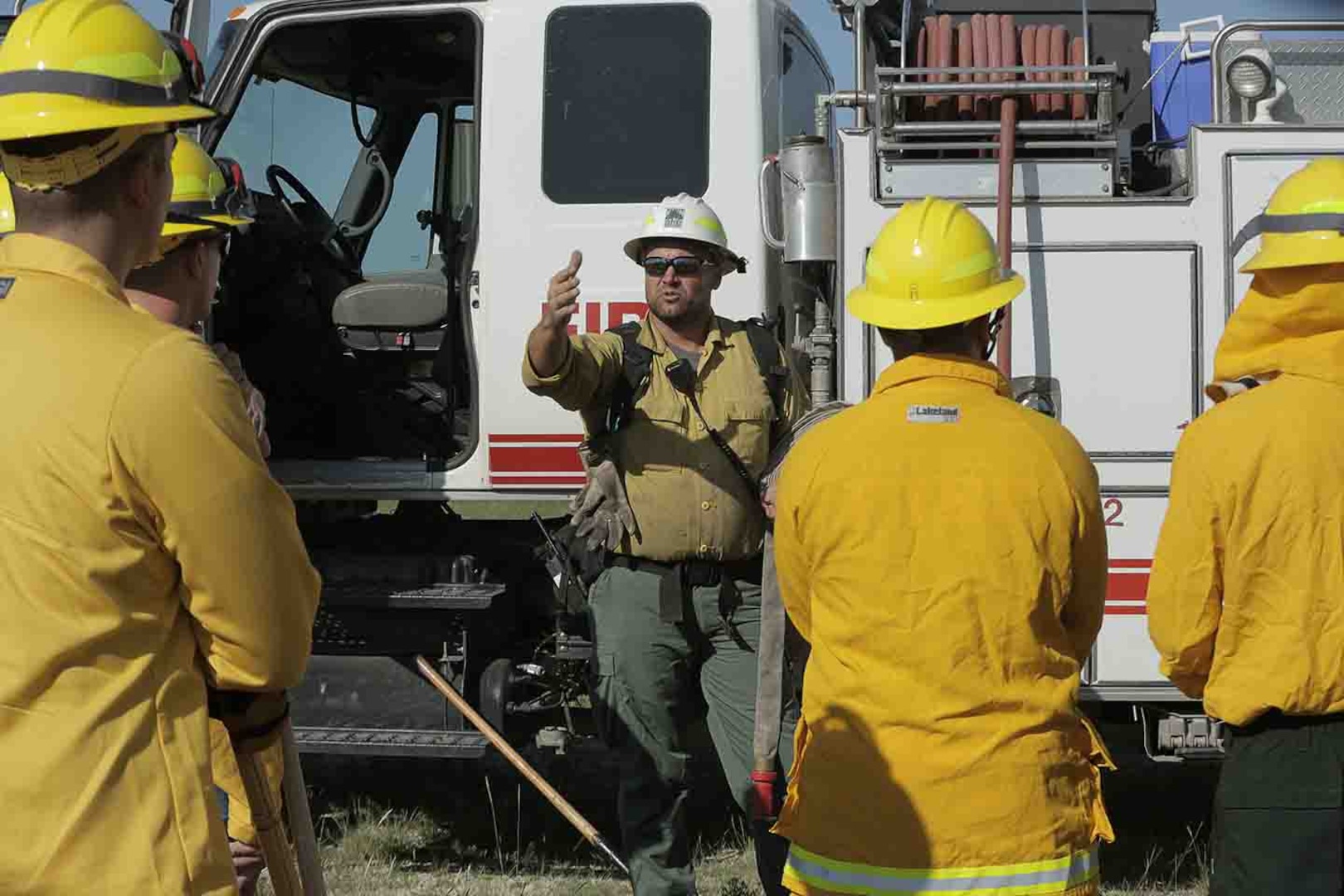 Bryce Haverkamp (center), eastern division fire officer, Kansas Forest Service, explains the operation of a water tender vehicle used by local fire departments. The Kansas Forest Service and fire departments from all over the state served as instructors to Soldiers and Airmen on firefighting capabilities at the Great Plains Joint Training Center in Salina, Kansas, Sep. 16-20, 2019.