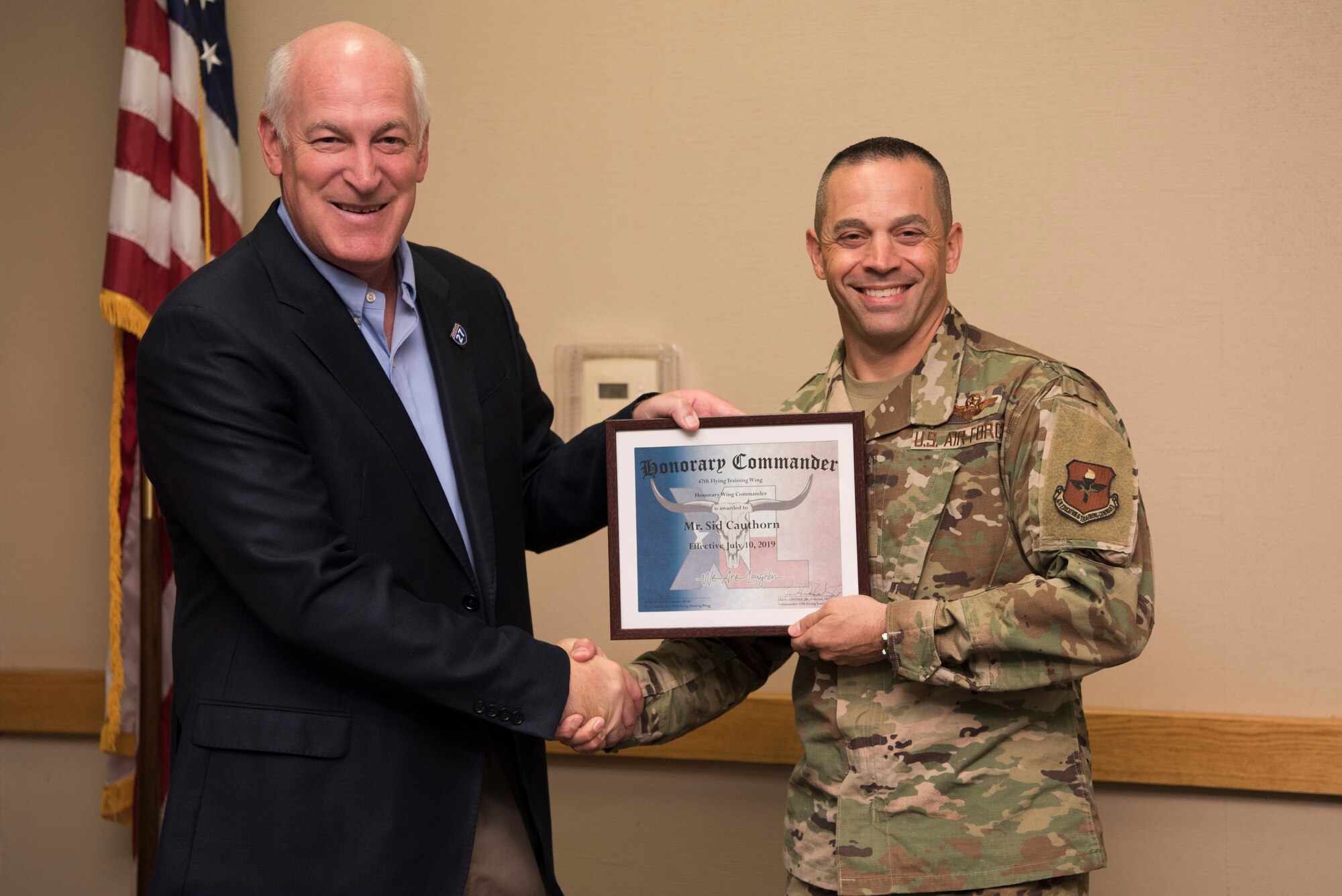 Sid Cauthorn, 47th Flying Training Wing honorary wing commander, receives an award from Col. Lee Gentile, 47th FTW commander, in Del Rio, Texas, Oct. 15, 2019. The honorary wing commander program enables the base and local community to develop and encourage the sharing of ideas, experiences and friendships. (U.S. Air Force photo by Senior Airman Marco A. Gomez)