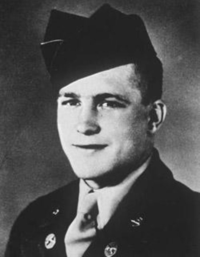 A soldier in his dress uniform smiles for an official photo.