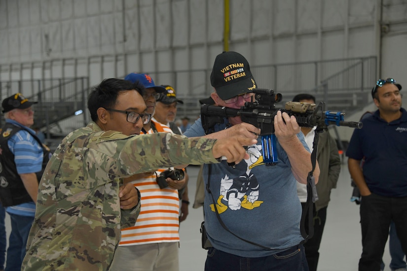 Staff Sgt. Colin Jamero, left, 11th Security Support Squadron, helps a Vietnam Security Police Association member with a simulated firing range during the association’s 25th anniversary held at Joint Base Andrews, Md., Oct. 10, 2019. During the day, the veterans were also shown a military working dog demonstration, and a weapons and equipment display, all while getting to spend some time with JBA defenders. (U.S. Air Force photo by Airman 1st Class Spencer Slocum)