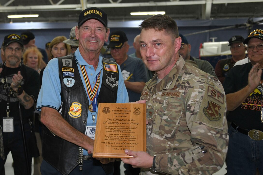 Jerry Nelson, Vietnam Security Police Association president, left, presents Col. Joseph A. Engelbrecht III, 11th Security Forces Group commander, a plaque of appreciation for hosting the assocaition’s 25th anniversary at Joint Base Andrews, Md., Oct. 10, 2019. The VSPA presented awards and challenge coins to multiple Airmen for supporting the VSPA event. (U.S. Air Force photo by Airman 1st Class Spencer Slocum)