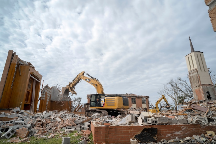 Industrial equipment tears down a building.