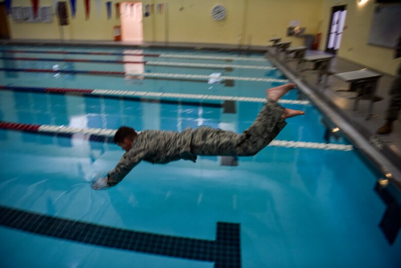 Staff Sgt. James Shanahan, a 47th Security Forces Squadron patrolman, jumps into a pool at Laughlin Air Force Base, Texas, Oct. 10, 2019. A total of 11 defenders volunteered for the pre-qualification stages to earn the German Armed Forces Badge for Military Proficiency. (U.S. Air Force photo by Senior Airman Marco A. Gomez)