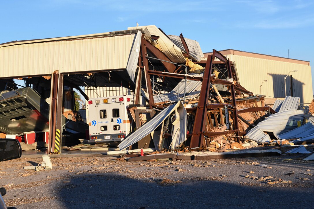 A facility housing an ambulance has crumbled down around a vehicle.