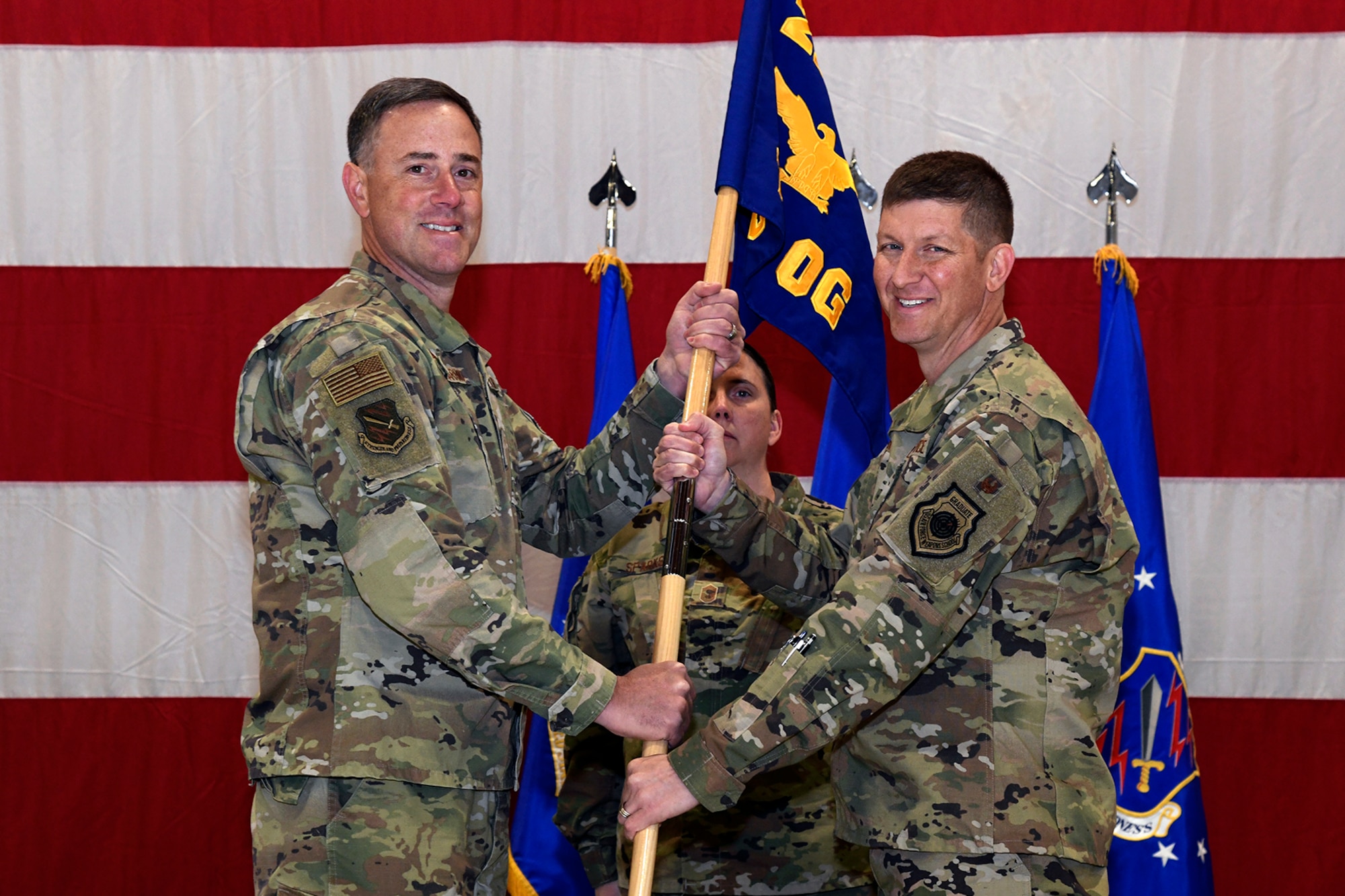 Col. Thomas Falzarano, 21st Space Wing Commander, passes the guidon to Col. John Thien, 721st Operations Group commander, during a ceremony activating the 721st OG Oct. 10, 2019 at Peterson Air Force Base, Colorado. The 721st OG will be singularly focused on securing the electromagnetic spectrum for national security space operations. (U.S. Air Force photo by Craig Denton)
