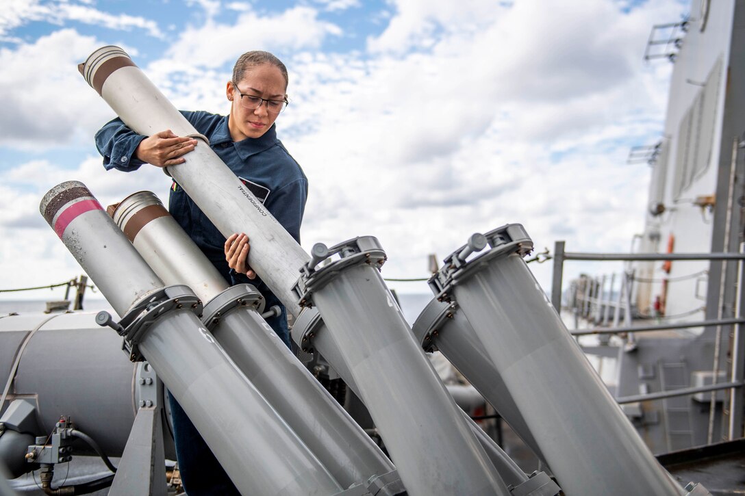 A sailor moves munitions.