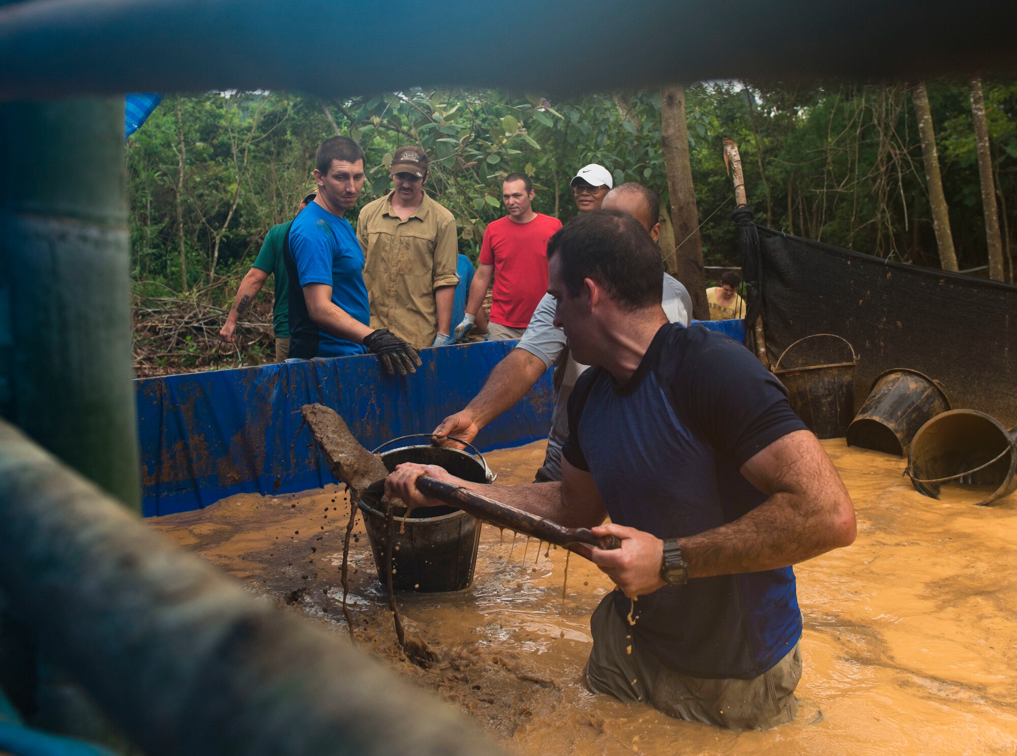U.S. Navy Equipment Operator 2nd Class Spencer Angel, Defense POW/MIA Accounting Agency (DPAA) recovery noncommissioned officer augmentee, shovels mud out of a wet screening station’s water supply during a DPAA recovery mission in Khammouan province, Lao People’s Democratic Republic, June 10, 2018. DPAA team members deployed to the area in hopes of locating U.S. service members who went missing from the Vietnam War. The mission of DPAA is to provide the fullest possible accounting for our missing personnel to their families and the nation. (U.S. Air Force photo by Staff Sgt. Mikaley Kline)