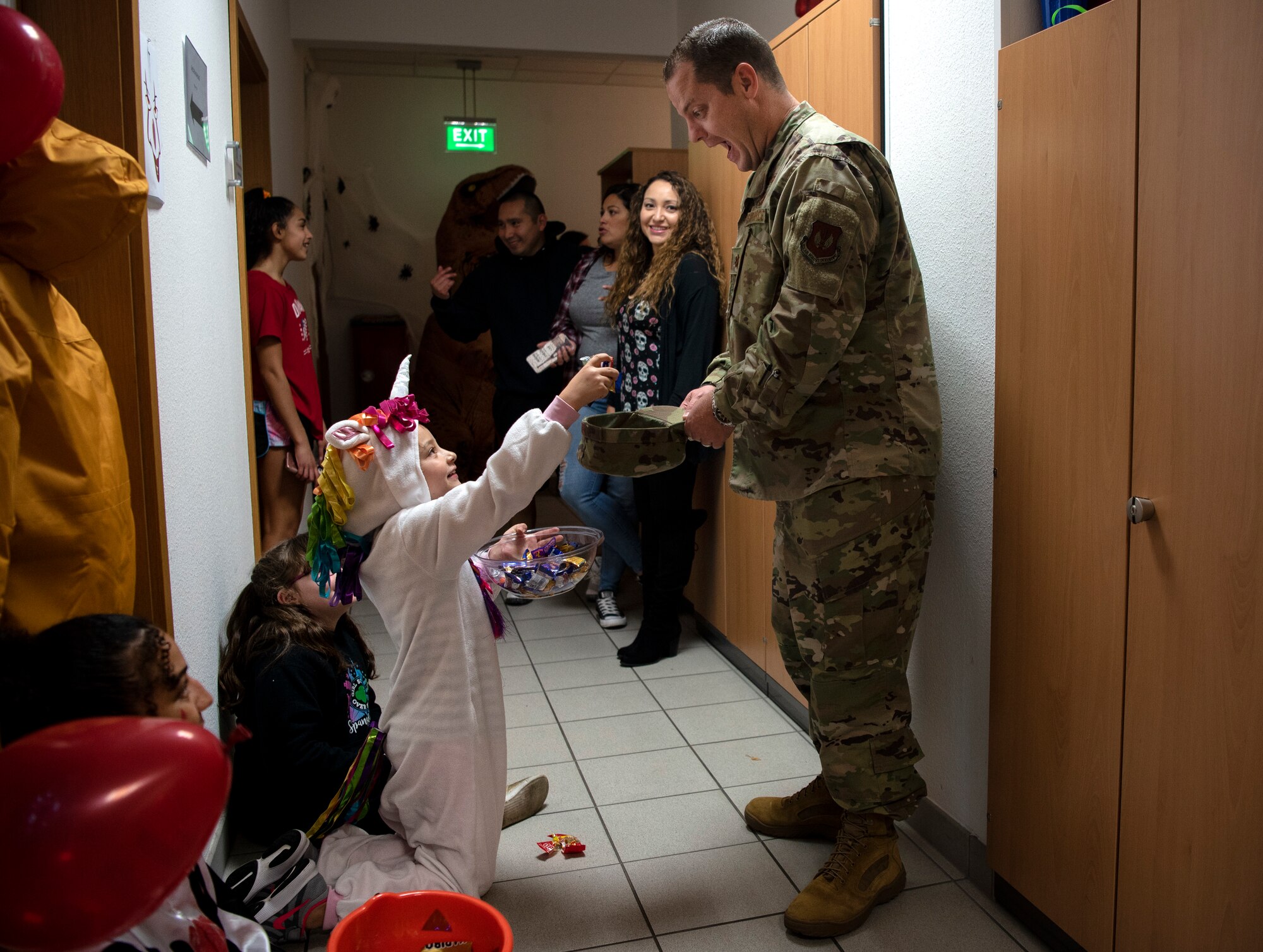 U.S. Air Force Maj. Shawn Schulz, 52nd Comptroller Squadron commander, right, trick-or-treats during a deployed-family event in the Airman and Family Readiness Center at Spangdahlem Air Base, Germany, Oct. 17, 2019. Deployed-family events are a monthly occurrence that provide activities and a meal to families. Base leadership and agencies provide support, services, and resources. (U.S. Air Force photo by Airman 1st Class Valerie Seelye)